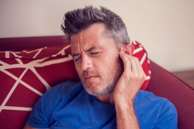 Tinnitus pain causes a man from Baton Rouge to wince in pain and put his hand on his ear to find relief. 