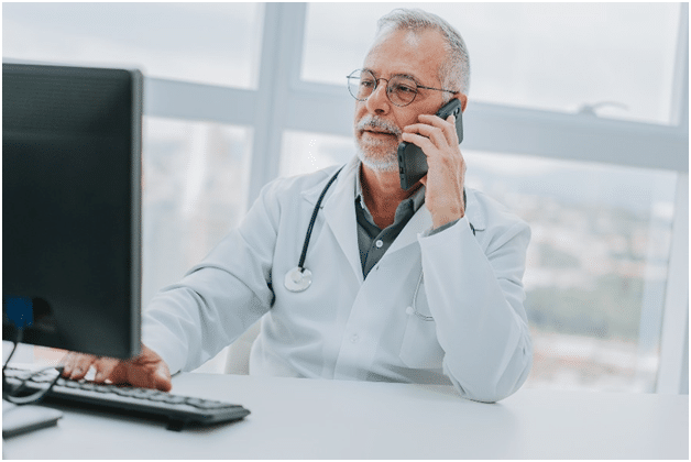 An audiologist from Estes Audiology schedules an appointment with his patient over the phone