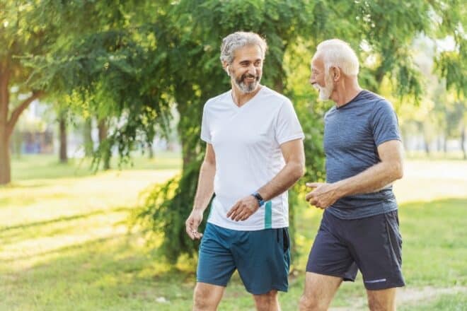 Two older men working out discussing their hearing health journey.